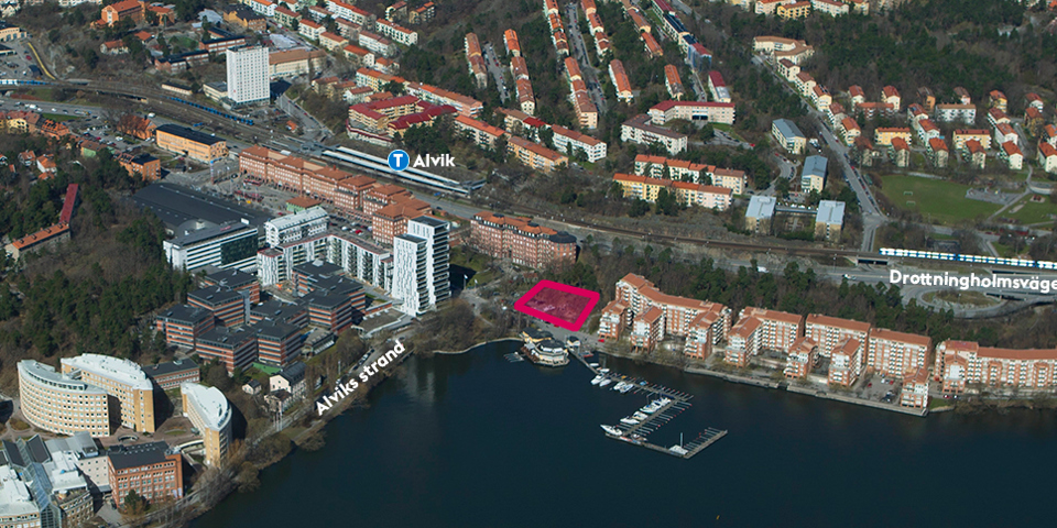 Flygfoto över Tranebergs strand och Alvik, med kontorshus, bostadshus och båtar vid båtklubb. Planområdet är markerat i rött. 